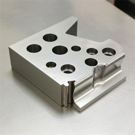 Bloque de metal con perforaciones y un diseño angular.